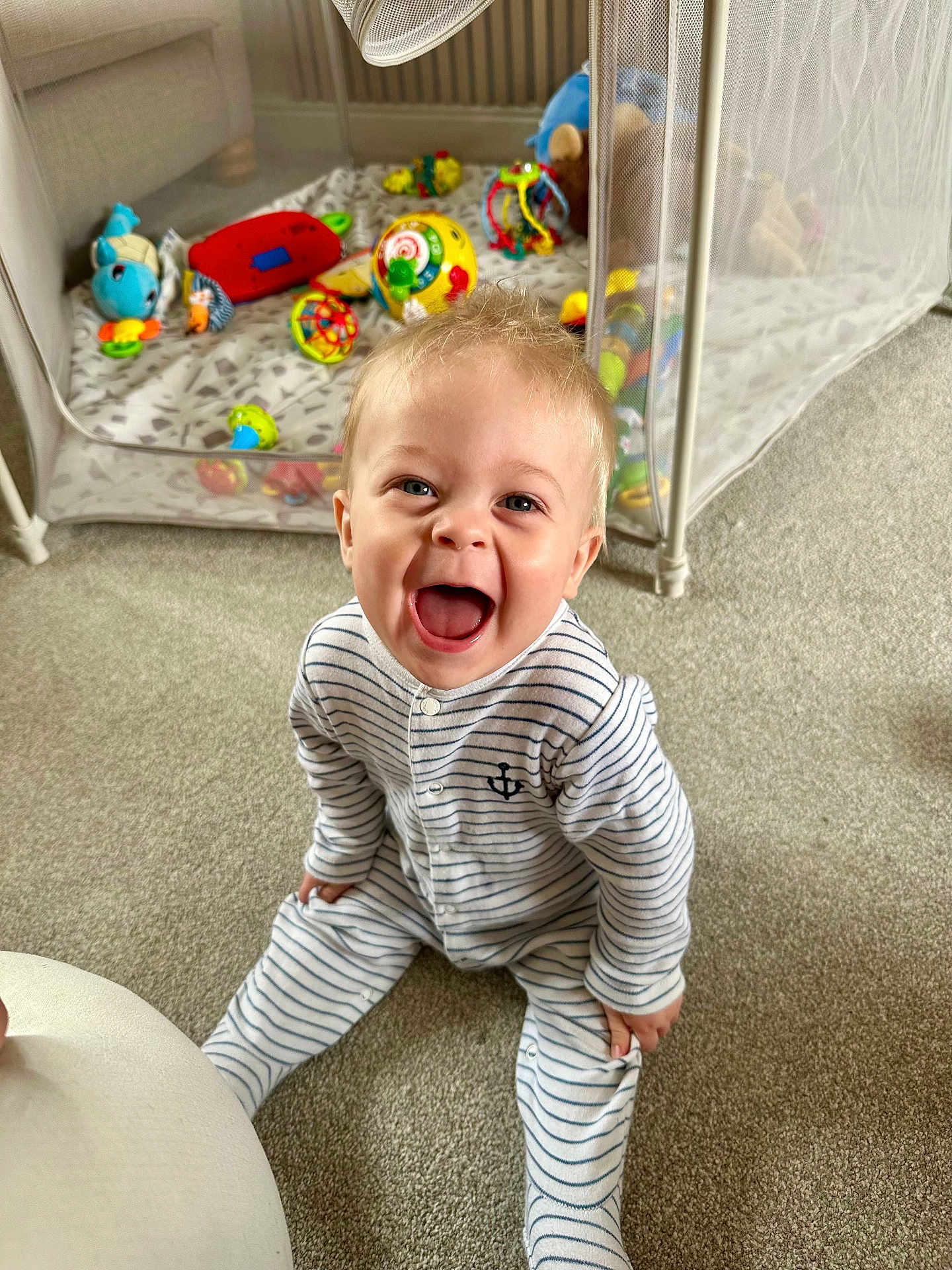 Oliver joined the competition — help win amazing prizes! baby, child, smiling, laughing, striped_onesie, indoor, carpet, playpen, toys, colorful, happy, sitting, cute, infant, person, home, playtime, joy, expression, face