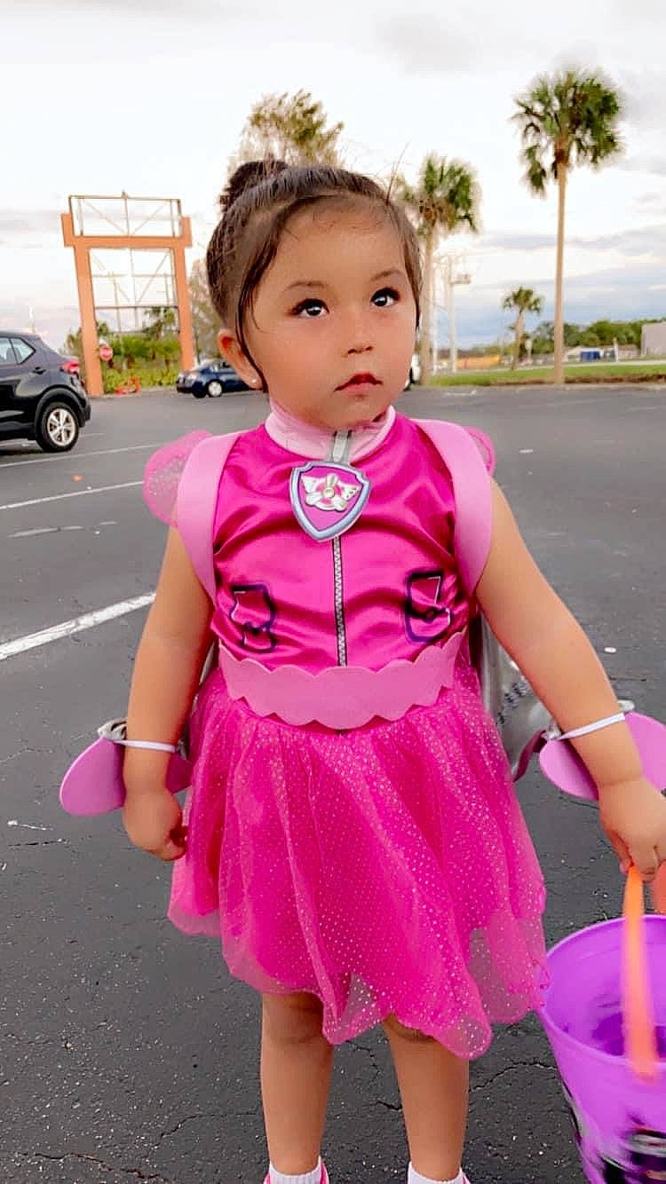 Faith is registered to the contest to win money with this photo: baby_toddler_clothing, child, day_dress, dress, electric_blue, face, fun, hairstyle, happy, magenta, one_piece_garment, palm_tree, pattern, person, pink, skin, sky, sleeve, summer, toddler