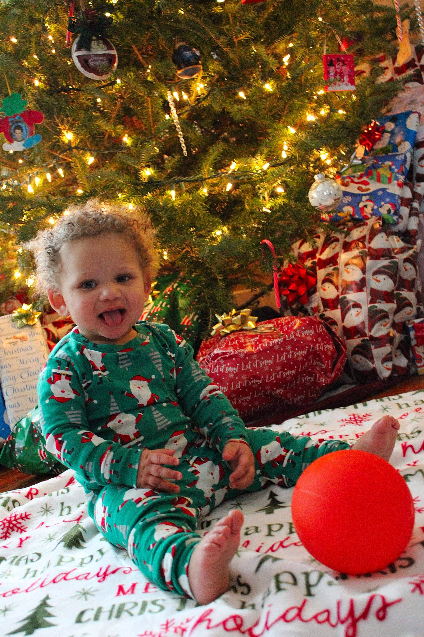 Joseph is registered to the contest to win money with this photo: baby_toddler_clothing, child, christmas, christmas_decoration, christmas_eve, christmas_lights, christmas_ornament, christmas_tree, conifer, event, holiday, holiday_ornament, human_body, interior_design, ornament, person, red, stuffed_toy, toddler, toy