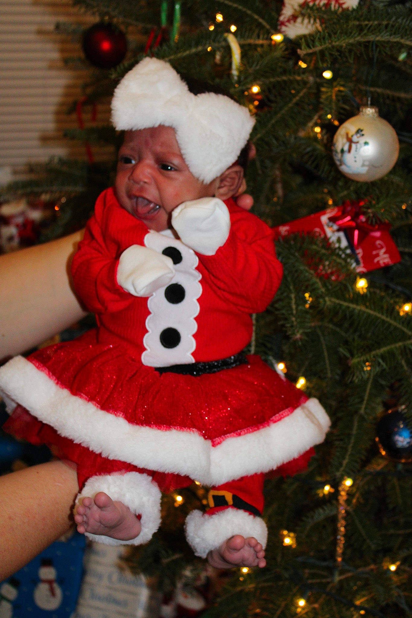 Elianna is registered to the contest to win money with this photo: christmas, christmas_decoration, christmas_eve, christmas_lights, christmas_ornament, christmas_tree, conifer, costume_accessory, event, fictional_character, fur, headwear, holiday, holiday_ornament, human, interior_design, ornament, person, red, toy