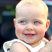 Delilah is registered to the contest to win money with this photo: baby, child, smiling, face, blue_eyes, skin, cheeks, arm, clothing, white_outfit, portrait, cute, happy, closeup, infant, people, young_child, human, expression, natural_light