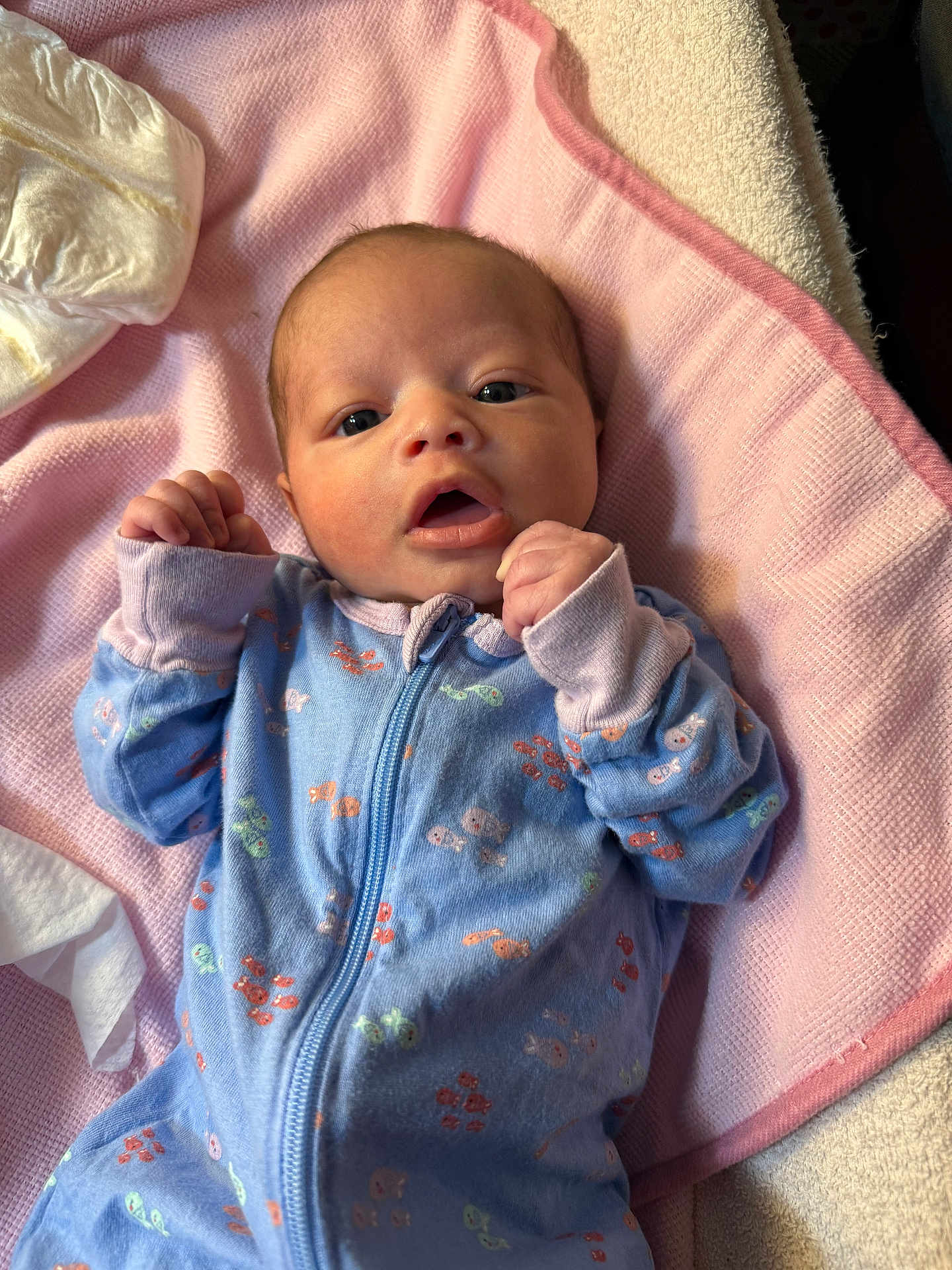 Jazilyna joined the competition — help win amazing prizes! baby, infant, newborn, face, eyes, mouth, hands, onesie, blue_onesie, blanket, pink_blanket, bedding, towel, diaper, portrait, cute, cozy, soft_texture, lying_down, indoor