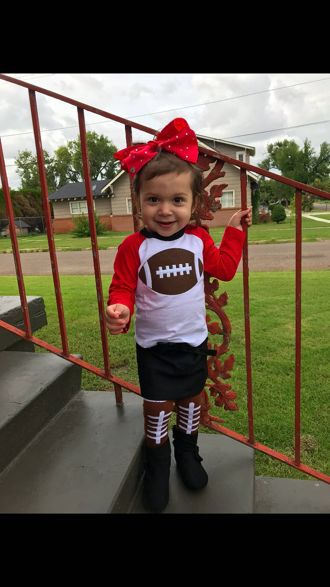 Cambrie is registered to the contest to win money with this photo: child, clothing, costume, day, facial_expression, fun, girl, headgear, joy, outerwear, person, play, playground, product, public_space, recreation, red, smile, standing, toddler