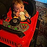 baby, bottle, toy_car, jeep, indoor, carpet, floor, child, milk, seat, hand, face, eyes, clothing, furniture, play, vehicle, cute, infant, sitting