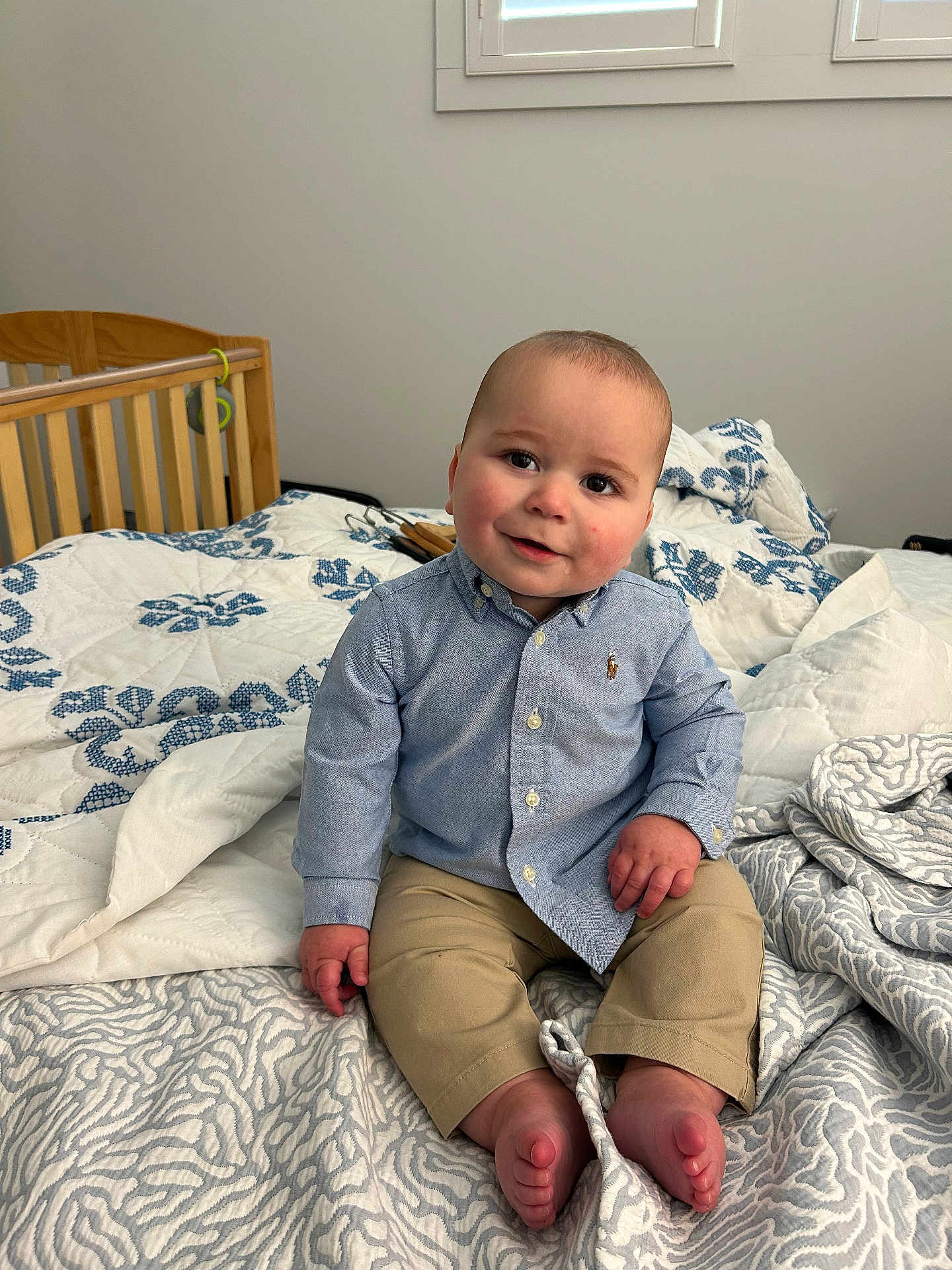 Ethan is registered to the contest to win money with this photo: baby, child, infant, bed, blanket, shirt, pants, barefeet, crib, window, indoor, smile, cute, portrait, person, furniture, home, cozy, clothing, sitting