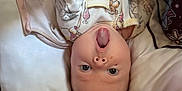 Dahlia joined the competition — help win amazing prizes! baby, infant, upside_down, pajamas, winnie_the_pooh, hands, face, expression, pillow, bed, tattoo, skin, clothing, cute, lying_down, person, child, indoor, young, surprised