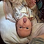 baby, infant, upside_down, pajamas, winnie_the_pooh, hands, face, expression, pillow, bed, tattoo, skin, clothing, cute, lying_down, person, child, indoor, young, surprised
