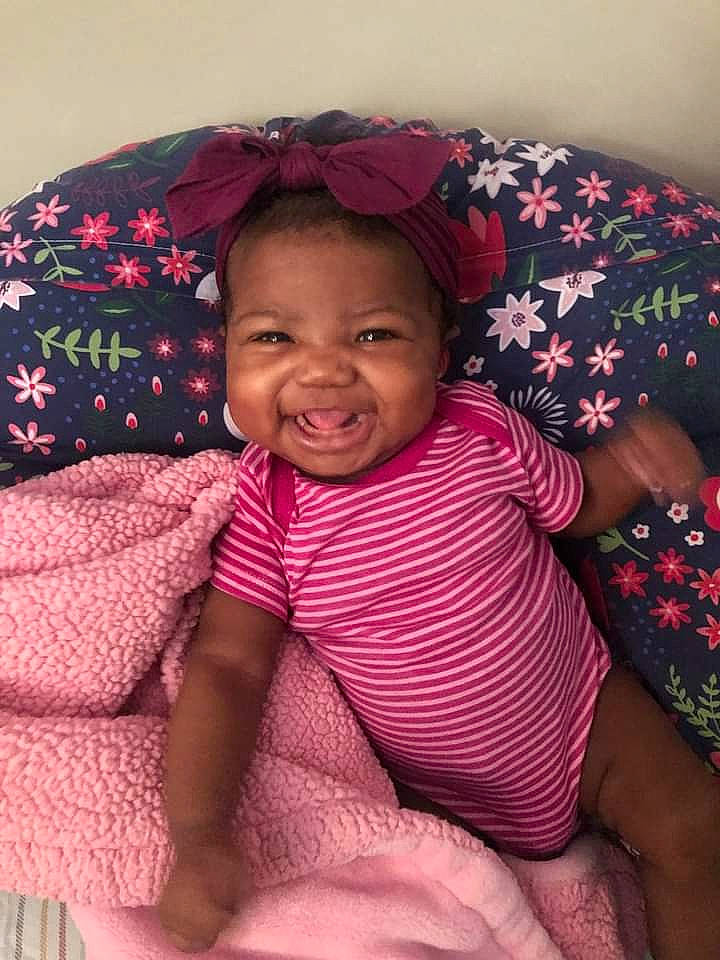 Ky'Una is registered to the contest to win money with this photo: child, chin, comfort, eye, face, facial_expression, finger, happy, head, human, human_body, lip, mammal, mouth, neck, person, pink, skin, sleeve, smile