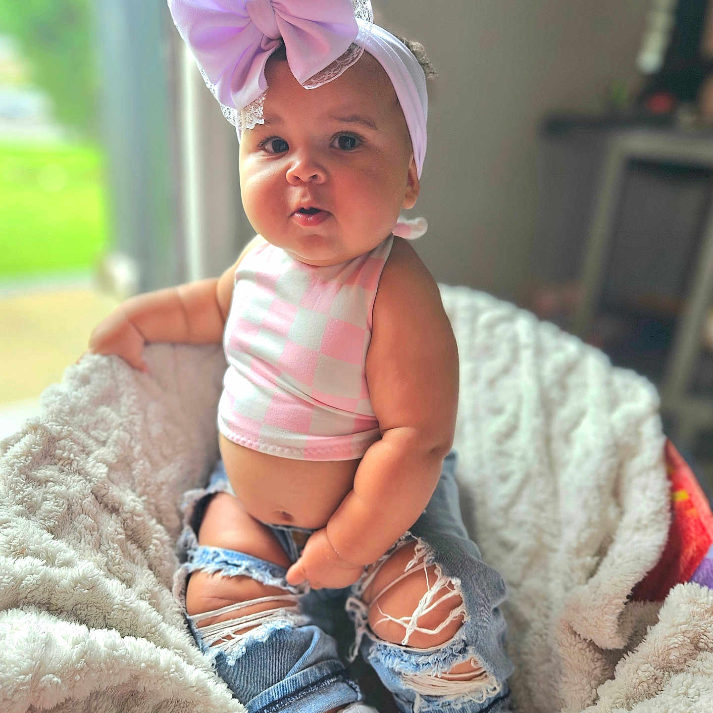 Nyla is registered to the contest to win money with this photo: baby, bonnet, cap, clothing, costume, face, footwear, happy, hat, head, jeans, pants, person, photography, portrait, shoe, shorts, sitting, smile, sunhat