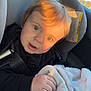baby, infant, child, car_seat, seat_belt, blanket, blue_eyes, blond_hair, portrait, sunlight, car_interior, window, hand, plush_blanket, cute, buckle, closeup, safety_label, face, looking_at_camera