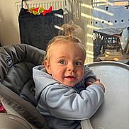 Maylan a rejoint le concours — aidez-le/la à gagner de superbes lots ! baby, toddler, child, highchair, tray, hoodie, hair_topknot, smile, cheeks, blue_eyes, indoor, sunlight, window, curtain, shadow_stripes, plush_toy, radiator, seat, feeding, portrait