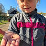 Lily-Rose participe au concours pour gagner de l'argent avec cette photo : child, ladybug, outdoor, sunlight, smile, hand, face, jacket, zipper, cap, nature, person, young, curious, blue_sky, building, greenery, spring, closeup, portrait