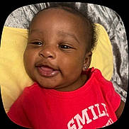 Zarya is registered to the contest to win money with this photo: baby, child, smiling, red_shirt, earrings, face, lying_down, yellow_pillow, gray_blanket, closeup, happy, cute, infant, portrait, skin, mouth, tongue, eyelids, indoor, person