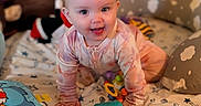 Stevie is registered to the contest to win money with this photo: baby, crawling, smiling, toy, blanket, pillow, indoor, child, face, hands, floor, clothing, colorful, pattern, cute, playtime, infant, happy, person, soft