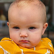 Stevie joined the competition — help win amazing prizes! apparel, baby, baby_fashion, child, closeup, cute, ears, eyes, face, fashion, giraffe_pattern, head, infant, outdoor, person, portrait, serious_expression, skin, yellow_clothing, young_child