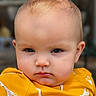 apparel, baby, baby_fashion, child, closeup, cute, ears, eyes, face, fashion, giraffe_pattern, head, infant, outdoor, person, portrait, serious_expression, skin, yellow_clothing, young_child