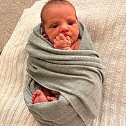 Elliana is registered to the contest to win money with this photo: newborn, baby, infant, child, portrait, swaddled, blanket, gray_blanket, baby_feet, tiny_hands, fist, hand_to_mouth, wide_eyed, lying_down, cozy, indoor, bed, textile, closeup, cute