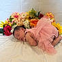 baby, newborn, sleeping, pink_dress, tutu, flowers, artificial_flowers, colorful, soft_surface, portrait, infant, cute, peaceful, resting, child, floral_arrangement, fabric, tulle, indoors, closeup