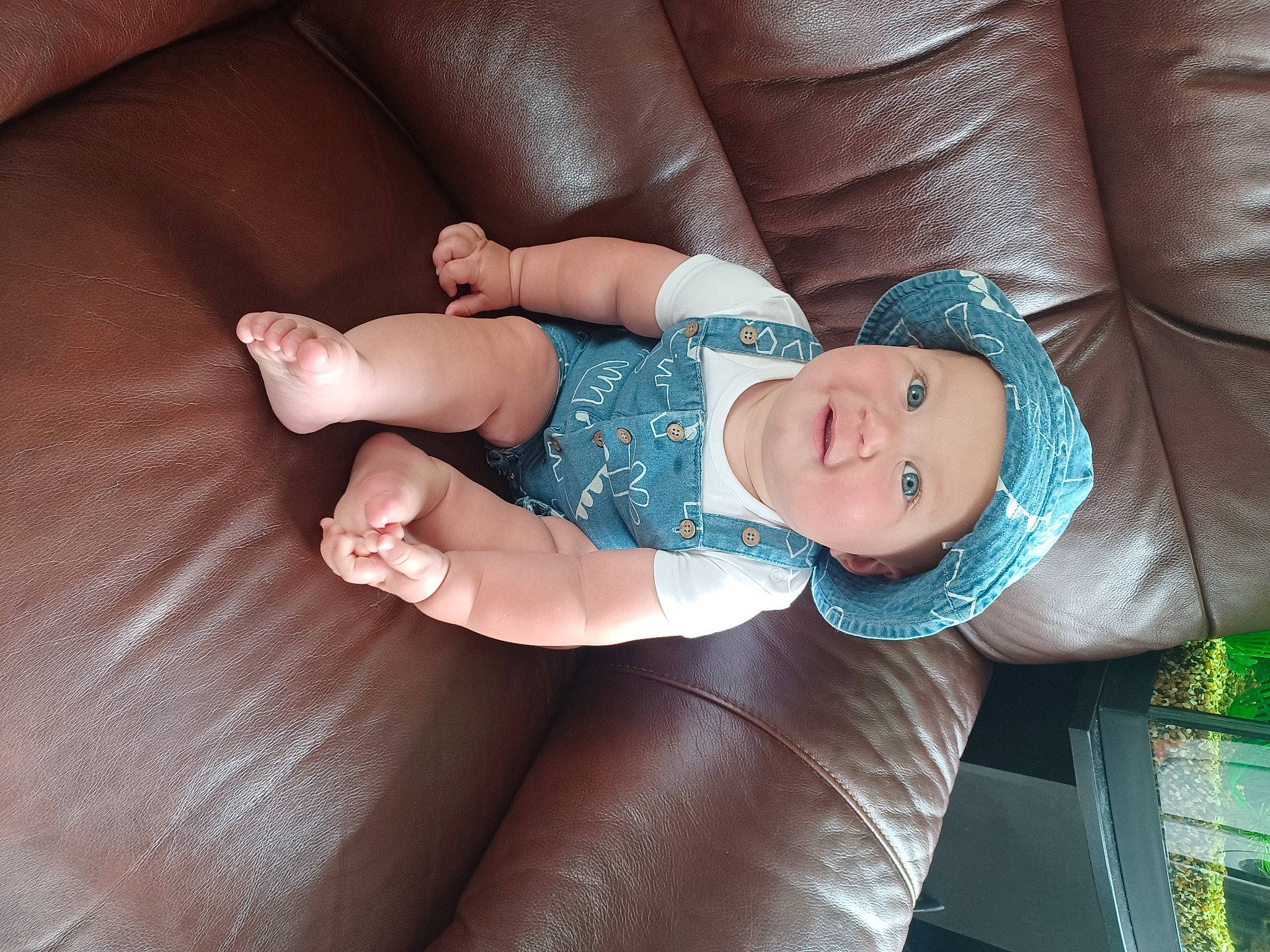 Freddie is registered to the contest to win money with this photo: baby, baby_toddler_clothing, cheek, child, comfort, finger, headwear, human_body, human_leg, joy, leg, nail, pattern, person, sitting, skin, sleeve, smile, sock, thigh
