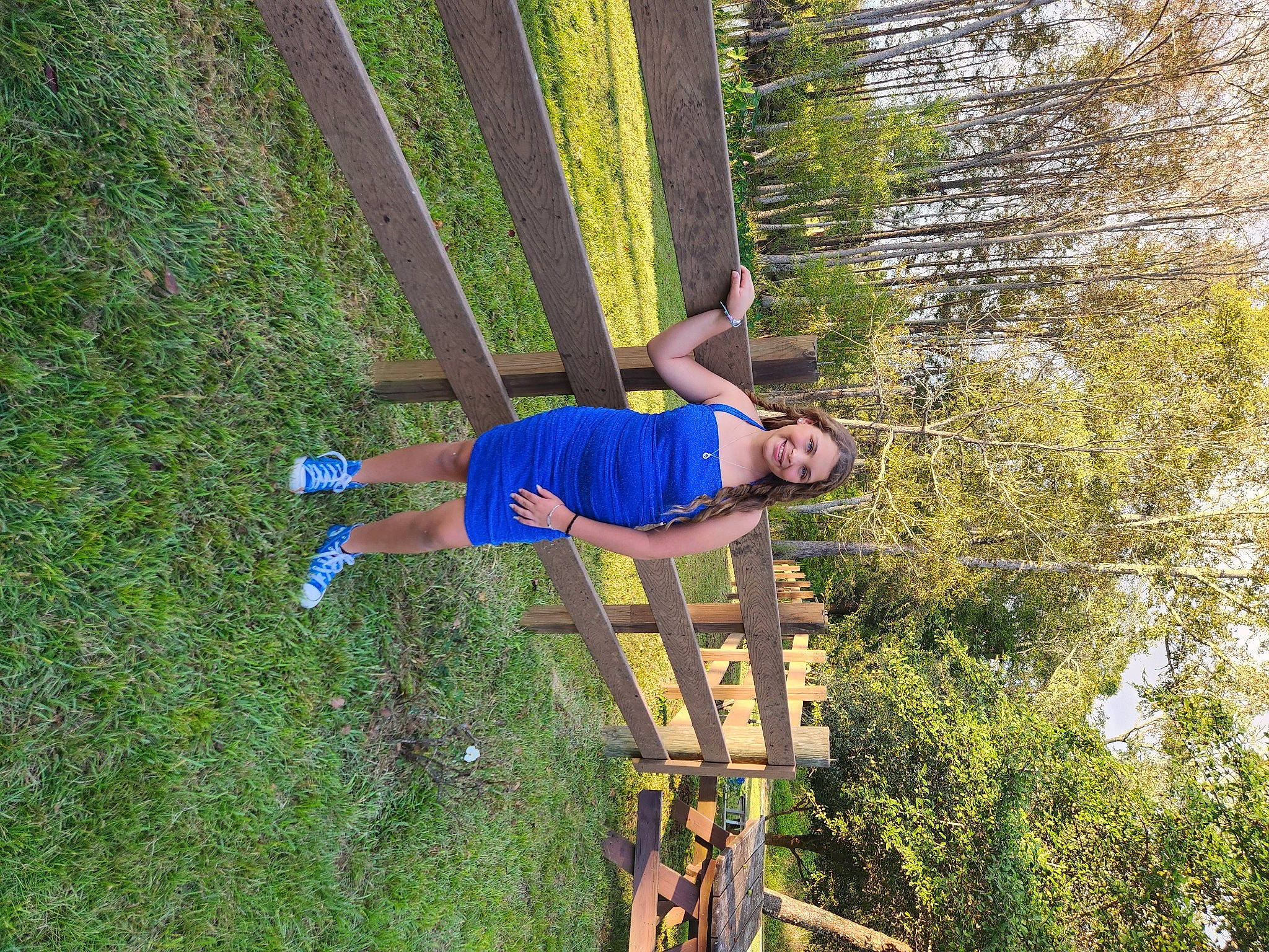 Mackenzie is registered to the contest to win money with this photo: elbow, electric_blue, fun, grass, grassland, joy, ladder, leisure, people_in_nature, person, plant, recreation, shorts, shrub, t_shirt, tree, wood