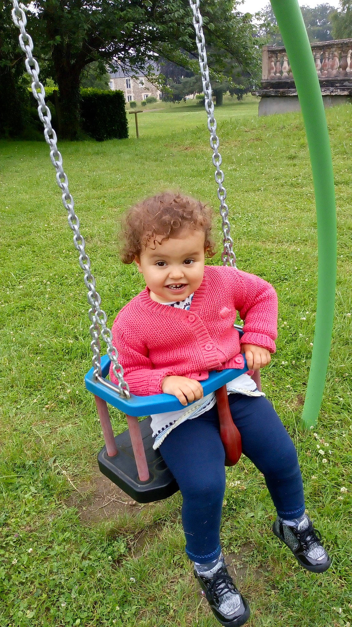 Lyla participe au concours pour gagner de l'argent avec cette photo : child, grass, joy, outdoor_play_equipment, person, play, playground, public_space, sitting, smile, swing, toddler