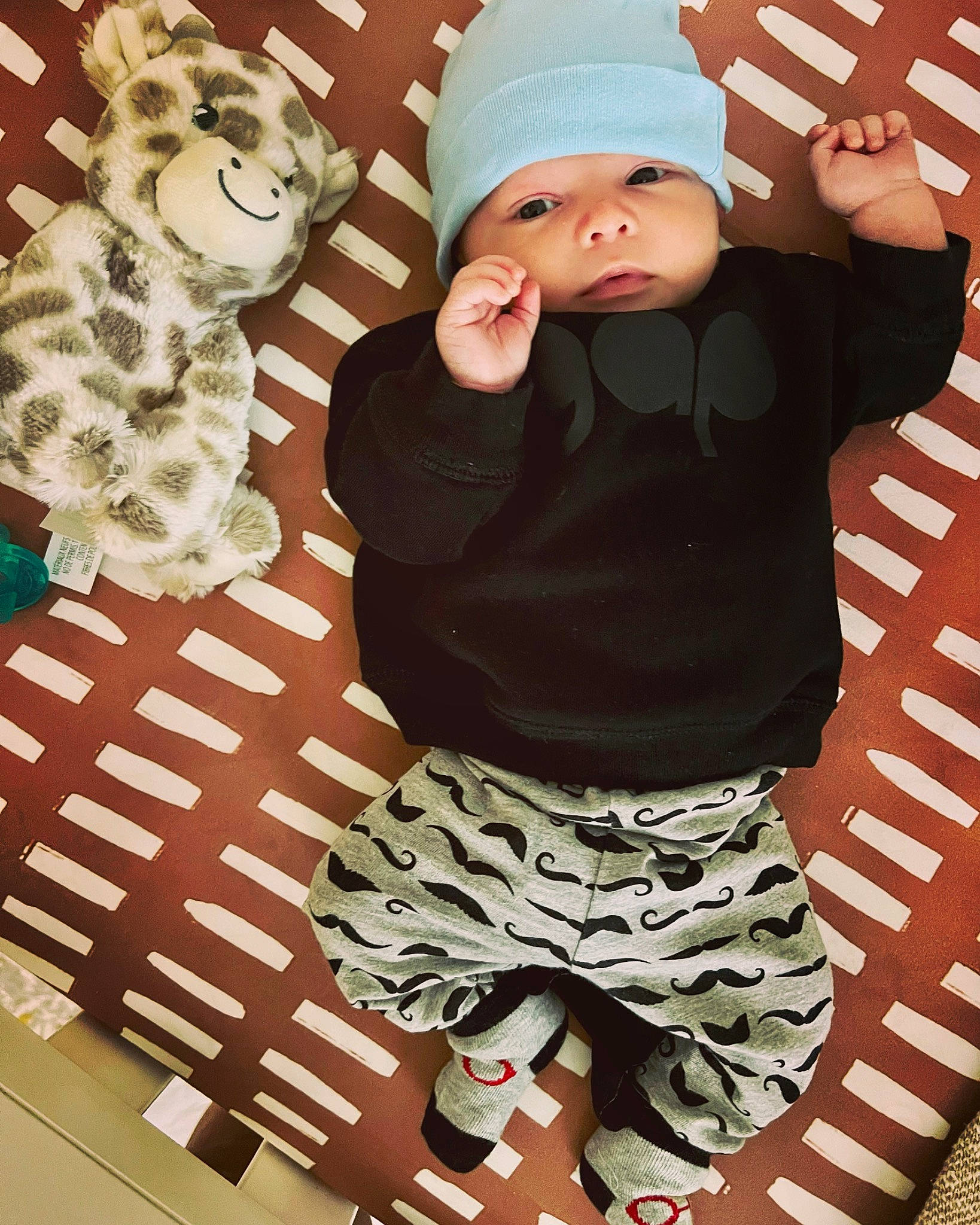 Killian joined the competition — help win amazing prizes! baby, baby_toddler_clothing, beanie, camouflage, cap, child, headgear, headwear, knit_cap, linens, military_camouflage, pajamas, pattern, person, pink, sleeve, sock, sportswear, t_shirt, thigh