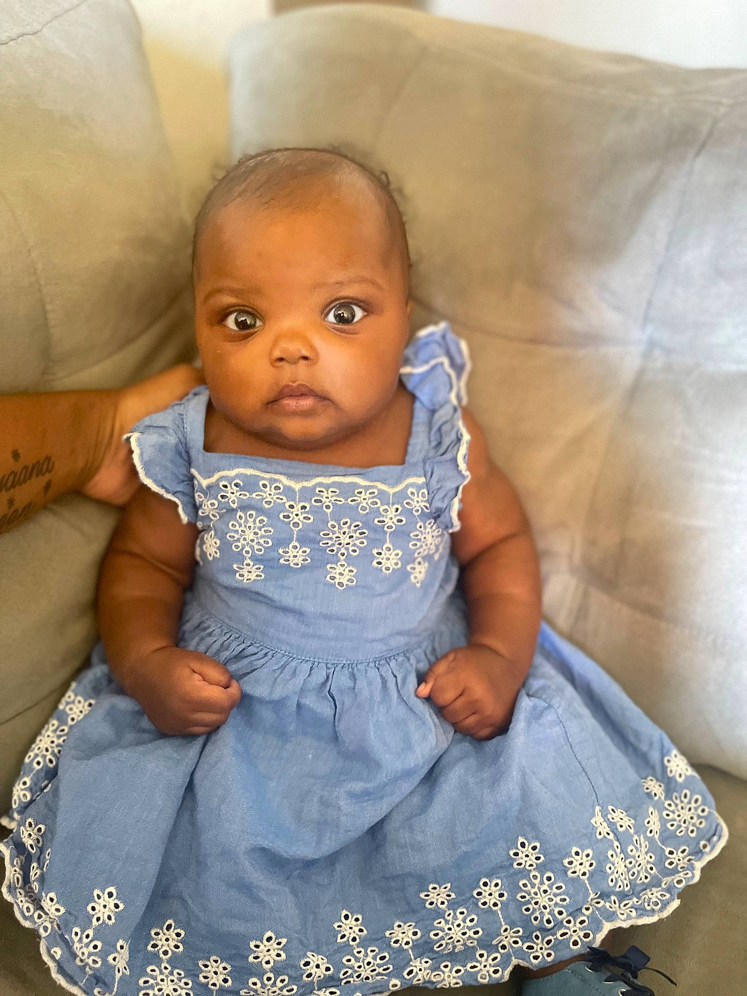 Khalia is registered to the contest to win money with this photo: baby, baby_toddler_clothing, chair, child, comfort, couch, dress, electric_blue, event, eye, face, hairstyle, happy, head, iris, jewellery, person, product, skin, textile