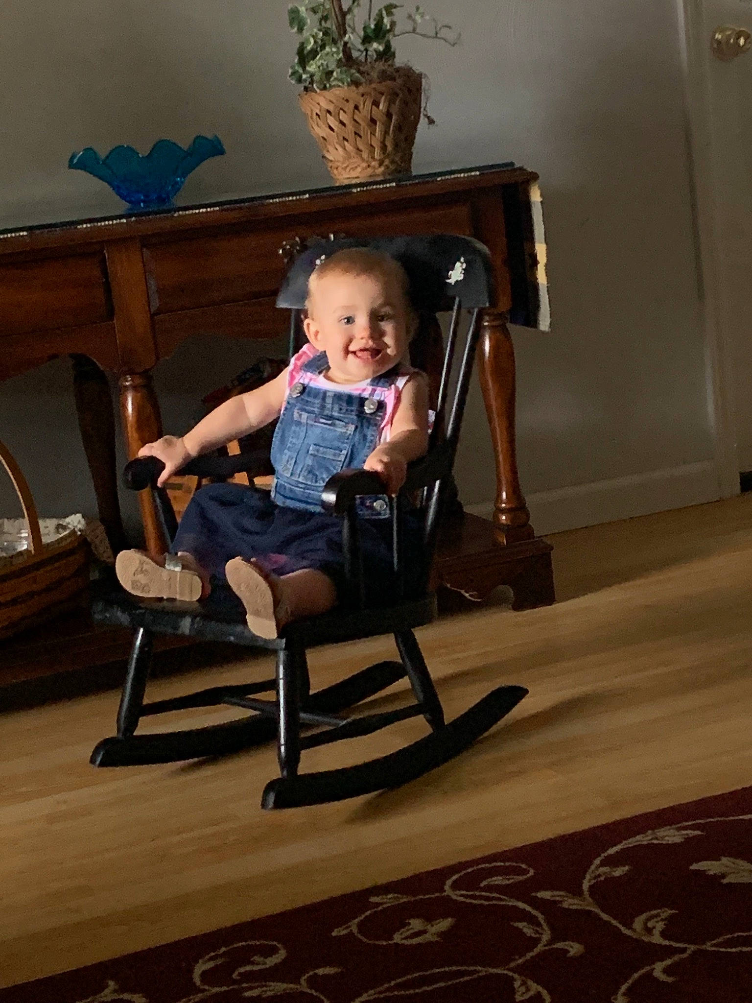 Madeline is registered to the contest to win money with this photo: chair, child, floor, flooring, fun, furniture, joy, leg, person, photography, rocking_chair, room, sitting, smile, toddler, vacation