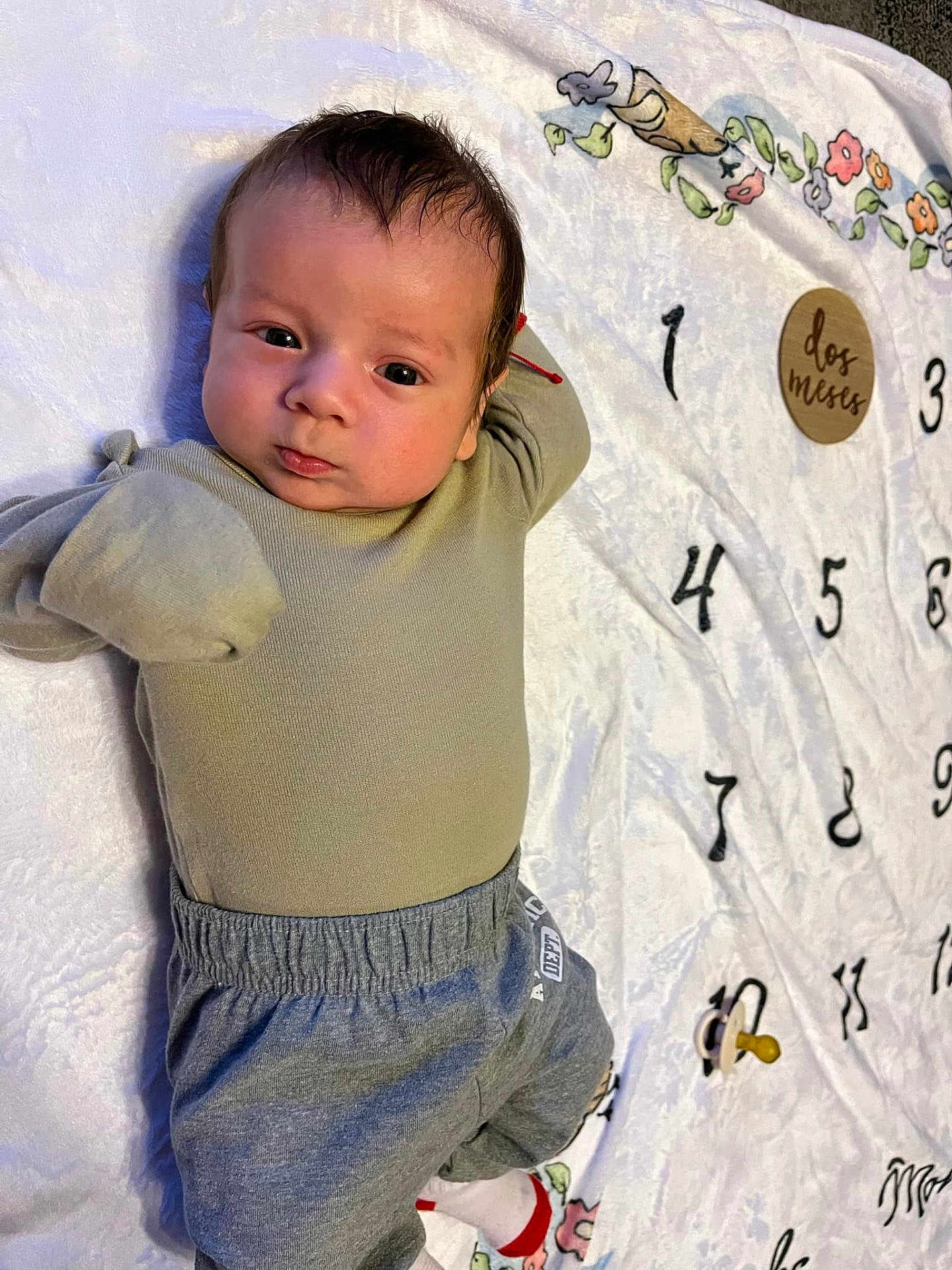 Eduardo joined the competition — help win amazing prizes! baby, infant, blanket, numbers, floral_pattern, clothing, pants, top, lying_down, face, head, expression, cute, indoors, soft_texture, pacifier, decorative, child, young, person