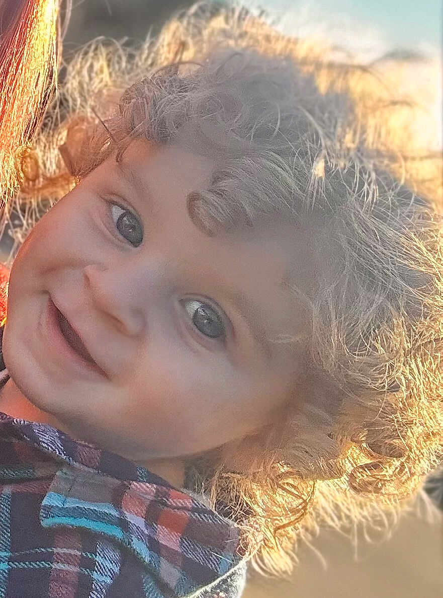 Logan joined the competition — help win amazing prizes! child, curly_hair, smiling, portrait, close_up, plaid_shirt, sunlight, happy, face, innocence, outdoor, young_child, cute, person, natural_light, curly_hair_child, joyful, headshot, warm_light, casual_clothing