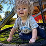 toddler, child, curly_hair, blue_eyes, swing, rope_swing, outdoor, playground, play_structure, slide, grass, sunny, smiling, grey_tshirt, navy_pants, happy, daytime, backyard, person, fun
