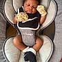 baby, sleeping, mittens, baby_seat, black_socks, cozy, infant, peaceful, giraffe_pattern, clothing, soft_pillow, child, resting, cute, indoor, comfort, newborn, person, portrait, nap