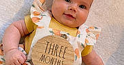 Everlee joined the competition — help win amazing prizes! baby, infant, child, smiling, headband, bow, peach_pattern, clothing, yellow_shirt, wooden_sign, milestone, three_months, blanket, cute, portrait, lying_down, chubby_cheeks, happy, indoor, soft_texture