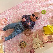 Everlee joined the competition — help win amazing prizes! baby, infant, sunglasses, crib, pink, floral, toy, stuffed_animal, baby_clothing, pants, long_sleeve_shirt, lying_down, indoor, child, cute, colorful, soft_toy, accessory, headwear, person