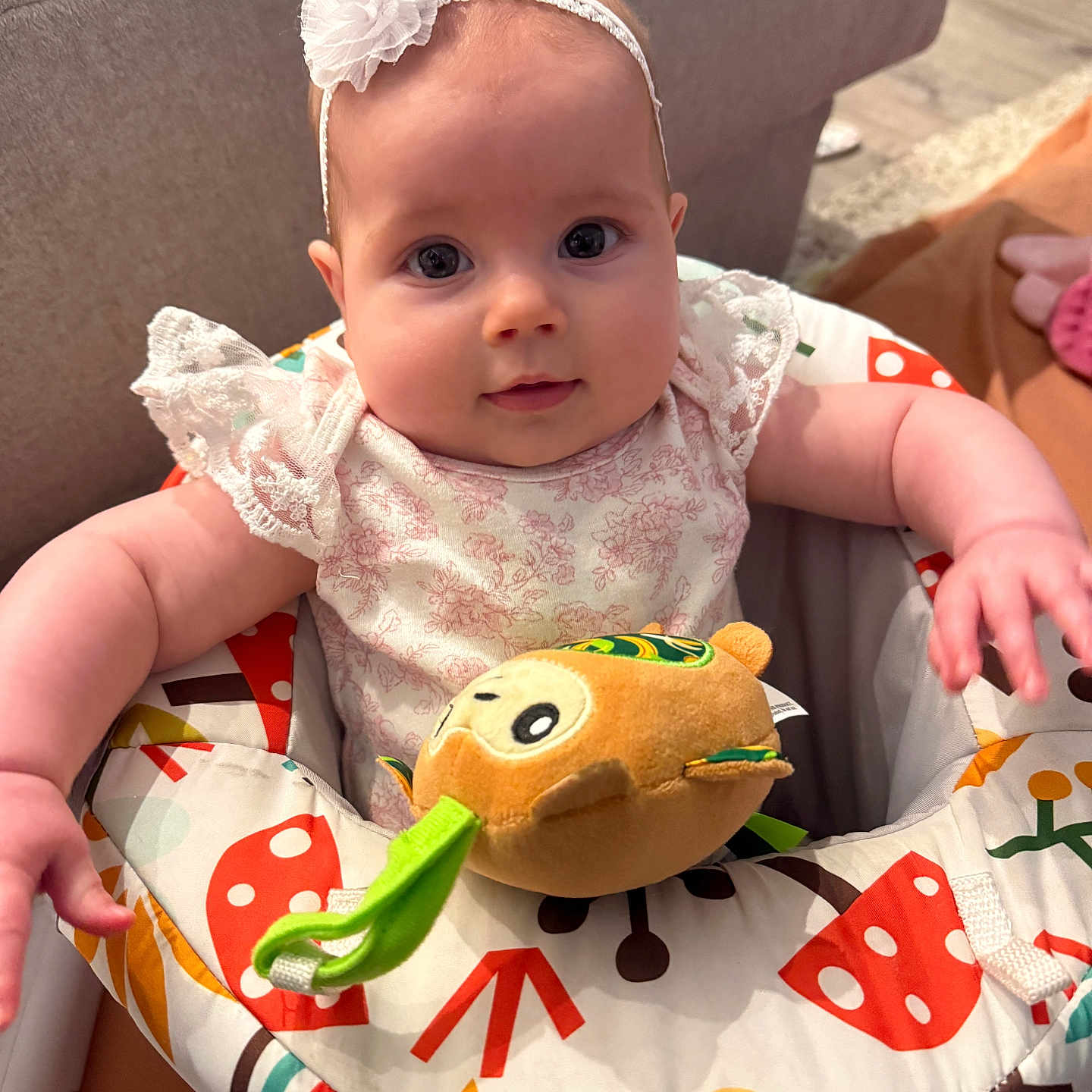 Everlee joined the competition — help win amazing prizes! baby, infant, headband, flower, plush_toy, colorful, baby_seat, mushrooms, cute, indoors, child, smiling, curious, soft_lighting, clothing, person, toddler, face, sitting, toy