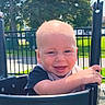 Atlas joined the competition — help win amazing prizes! baby, child, playground, swing, smiling, happy, outdoor, park, infant, face, portrait, sunlight, trees, grass, fence, play_equipment, safety_bar, seated, grinning, daylight