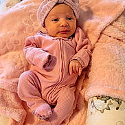 Zoey joined the competition — help win amazing prizes! baby, infant, pink, blanket, headband, onesie, cute, soft, cozy, sleeping_bag, newborn, baby_nest, animal_print, cushion, portrait, indoors, child, comfort, relaxation, hand