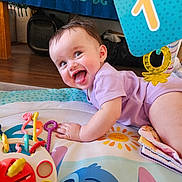 Brooklyn joined the competition — help win amazing prizes! baby, blanket, cheek, child, colorful, crawling, face, hand, hanging_toy, happy, hardwood_floor, indoor, number_one_tag, play_mat, purple_onesie, smiling, sun_illustration, teething_toy, tongue_out, toy