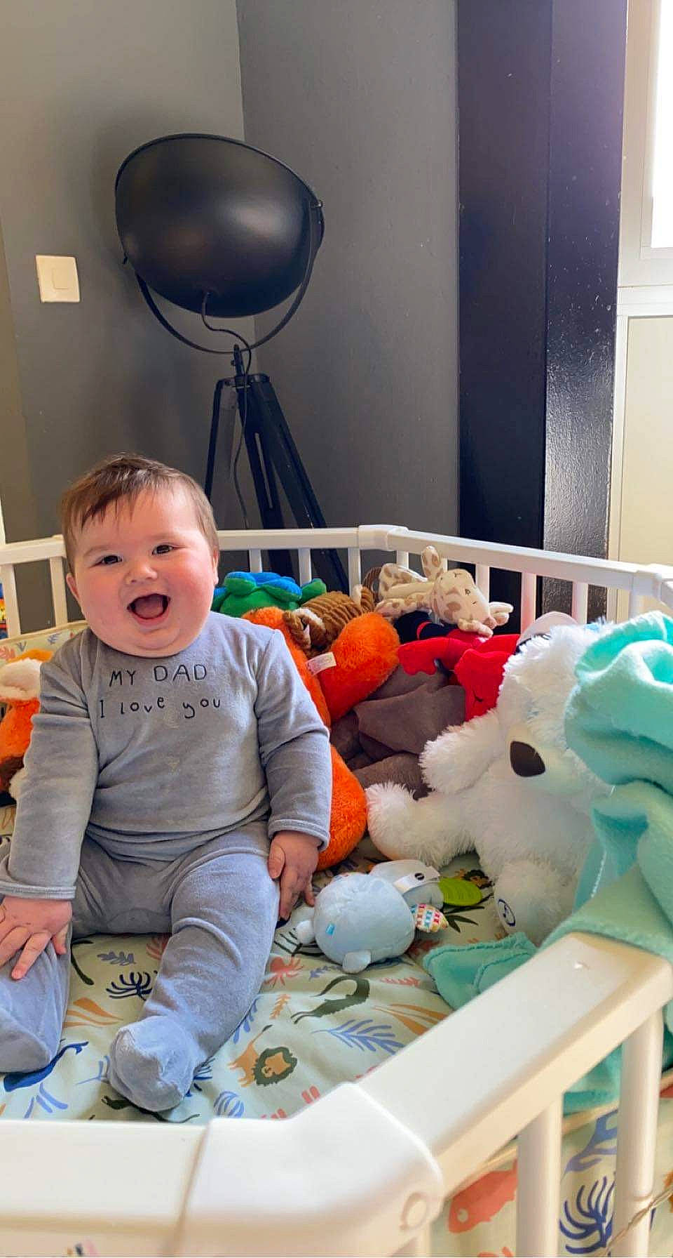 Eden a rejoint le concours — aidez-le/la à gagner de superbes lots ! baby, baby_products, baby_toddler_clothing, child, comfort, flooring, fun, fur, happy, lamp, mechanical_fan, person, plush, room, sitting, smile, t_shirt, teddy_bear, toddler, toy