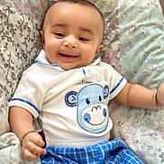 Ram is registered to the contest to win money with this photo: baby, smiling, infant, cute, clothing, shirt, pants, blue, white, patterned_cushion, happy, child, portrait, indoor, comfort, soft, face, expression, baby_boy, casual
