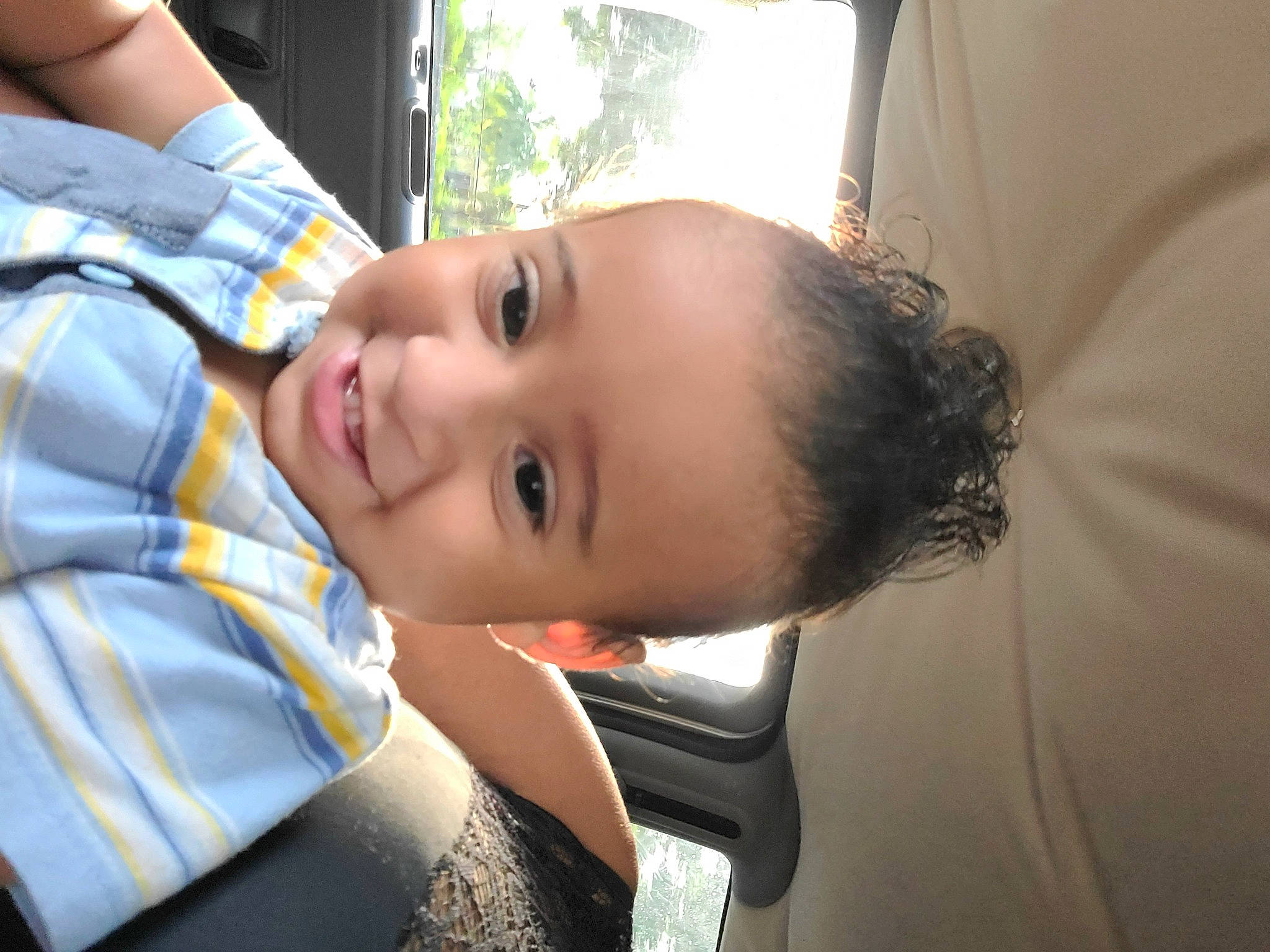 Osvaldo is registered to the contest to win money with this photo: black_hair, cheek, child, cool, eyebrow, eyelash, fun, grass, happy, joy, leisure, lip, mouth, nose, person, sitting, skin, smile, toddler, tree