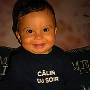 Loan a rejoint le concours — aidez-le/la à gagner de superbes lots ! baby, background_blur, black_hair, child, closeup, couch, cute, dark_clothing, face, happy, indoors, infant, long_sleeves, person, portrait, sitting, smiling, text_on_clothing, warm_lighting, young_child
