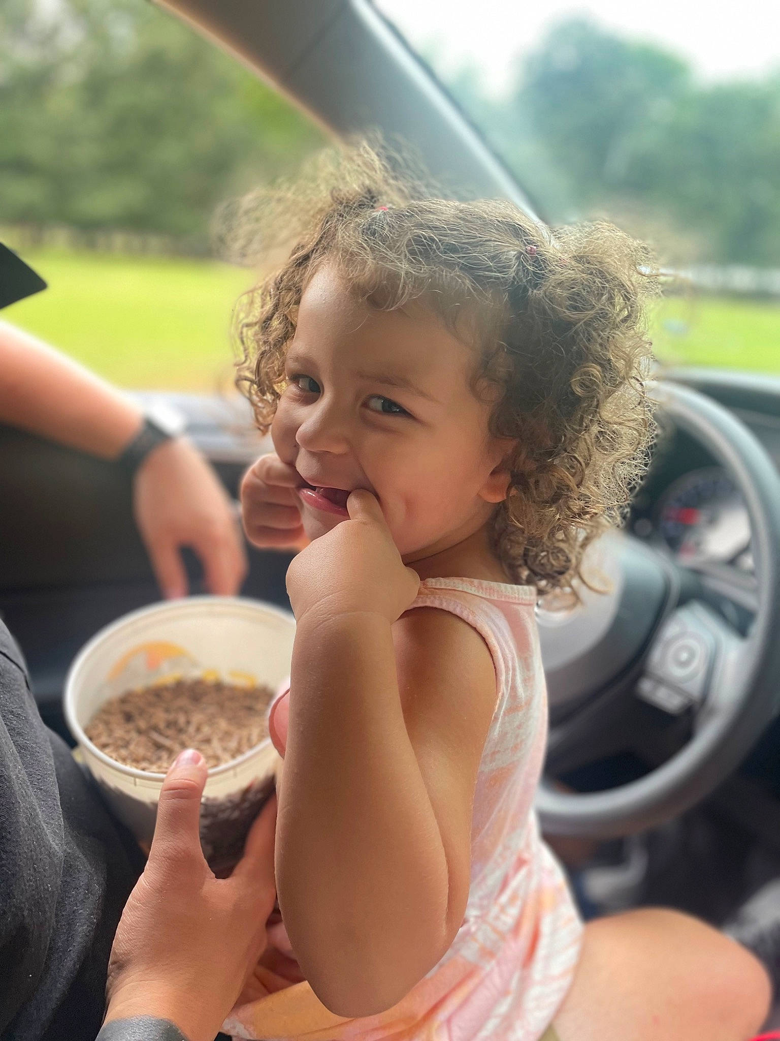 Kenlynn is registered to the contest to win money with this photo: automotive_exterior, automotive_mirror, child, finger, food, fun, gesture, hand, happy, joy, leisure, motor_vehicle, person, personal_luxury_car, skin, smile, steering_wheel, summer, toddler, tree