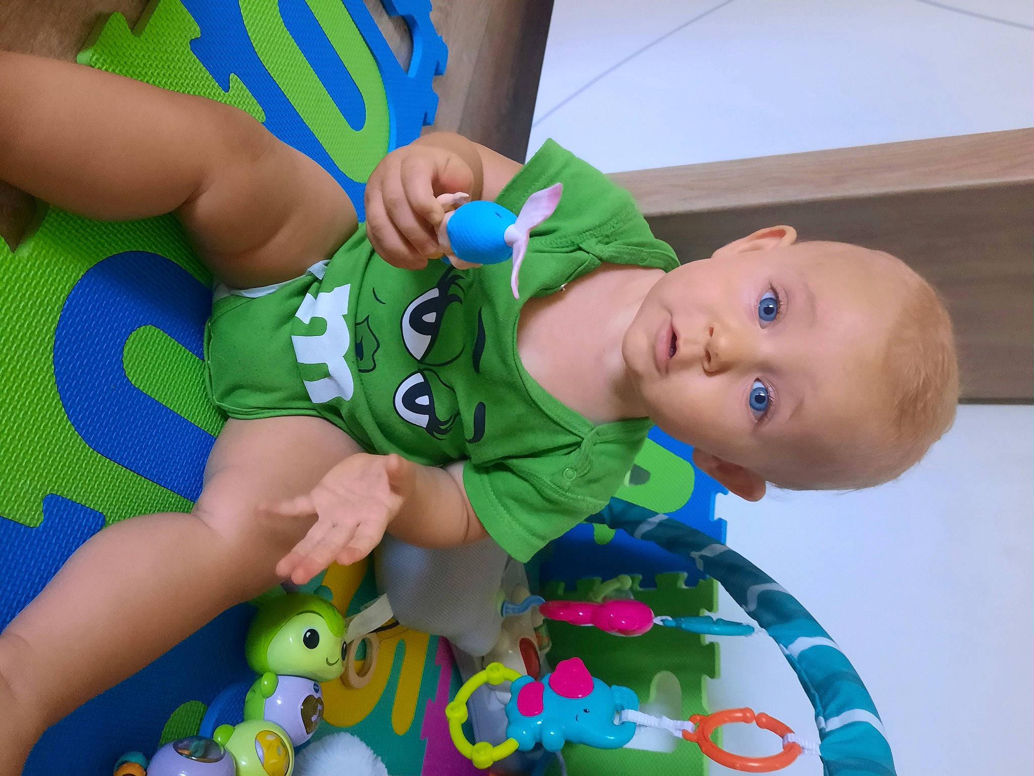 Célina participe au concours pour gagner de l'argent avec cette photo : baby, baby_products, baby_toddler_clothing, baby_toys, chair, child, electric_blue, fun, green, hand, happy, hat, leg, pattern, person, sock, sportswear, surprise, thigh, toddler