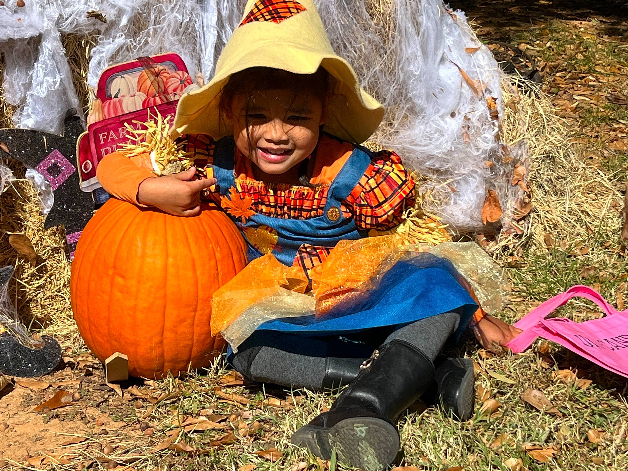Lamya is registered to the contest to win money with this photo: adaptation, calabaza, child, fun, goggles, gourd, grass, happy, hat, nature, people_in_nature, person, plant, pumpkin, sitting, smile, soil, squash, toddler, vegetable