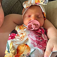 Isabelle is registered to the contest to win money with this photo: baby, child, sleeping, pacifier, headband, floral, blanket, arm, hand, phone, indoor, couch, comfort, peaceful, cute, person, portrait, rest, young, toddler