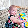 Nova joined the competition — help win amazing prizes! toddler, child, smile, dress, floral_pattern, book, outdoor, wooden_deck, reading, colorful, playful, young_child, happy, barefoot, daylight, person, cute, summer, sitting, blue_eyes
