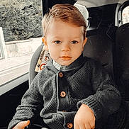 Rafaël a rejoint le concours — aidez-le/la à gagner de superbes lots ! child, toddler, car_seat, seatbelt, sweater, buttoned_clothing, car_interior, window, road_outside, hair, face, hands, looking, curious, pout, indoor, daylight, portrait, text_overlay, cozy
