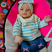 Romy a rejoint le concours — aidez-le/la à gagner de superbes lots ! baby, infant, child, headband, striped_shirt, denim_skirt, pink_bows, colorful_cushion, polka_dots, pink, blue, white_tights, indoor, smiling, cute, portrait, seated, soft_fabric, cozy, playful