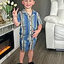 Matthew is registered to the contest to win money with this photo: child, boy, smiling, indoor, peace_sign, striped_clothing, shorts, shirt, sandals, floor, vase, tulips, flower, decor, fireplace, leather_chair, wood_floor, happy, person, home